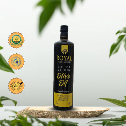 Product image of Royal Bolan Golden Drops Extra Virgin Olive Oil on a wooden board with green leaves in the background